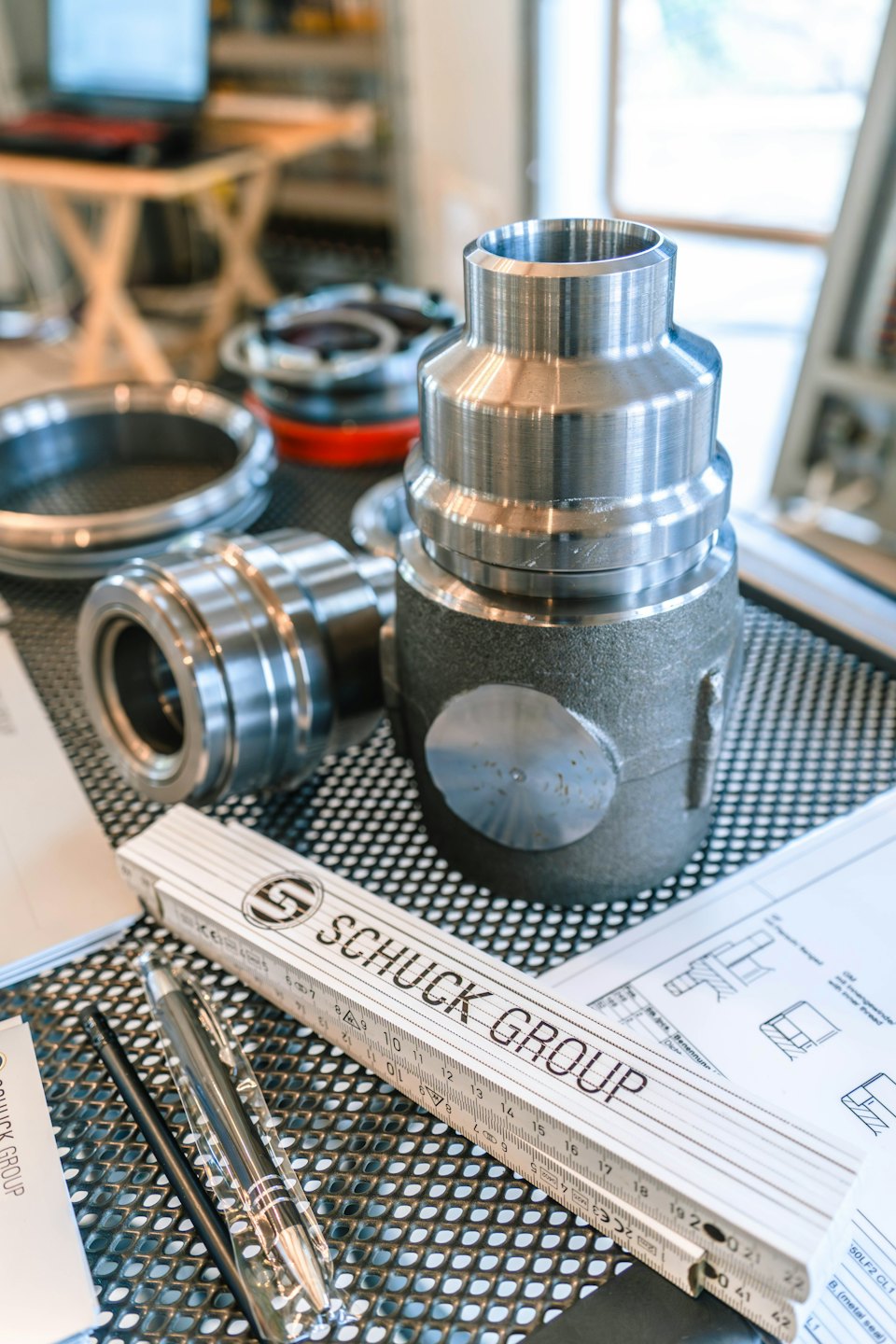 Machined metal parts and engineering tools on a workshop surface.